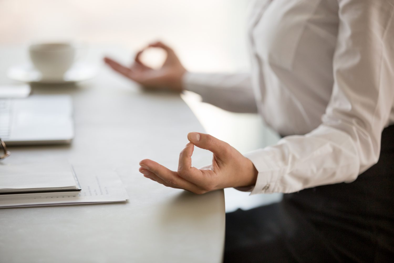 Professional woman meditating at her work desk