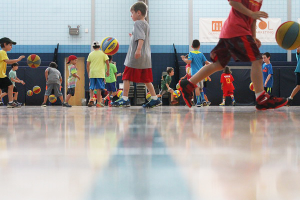 Group of kids play basketball in the gym