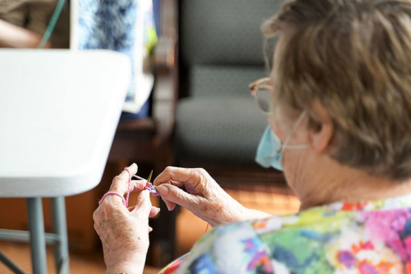 woman knitting at Shalom Austin's Mitzvah Knitters